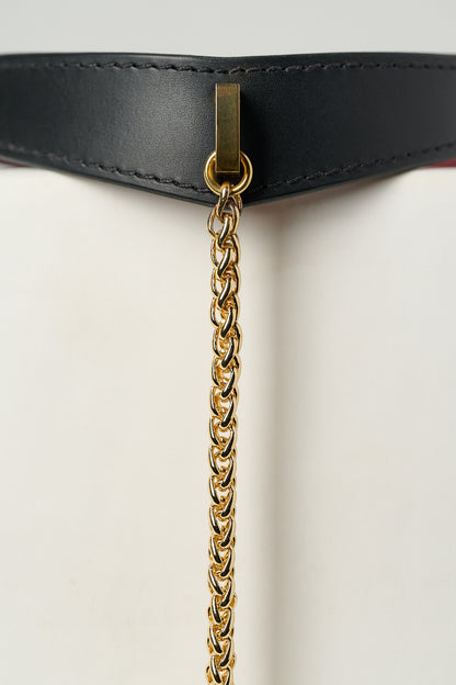 Gold chain attached to a black necklace on a white background